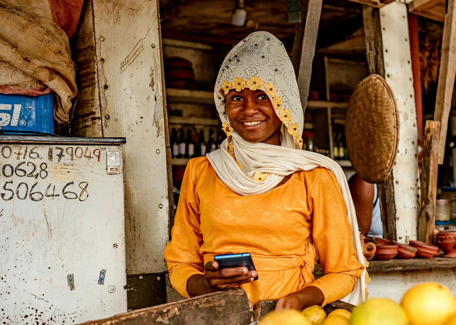 Commerçante souriante utilisant son téléphone